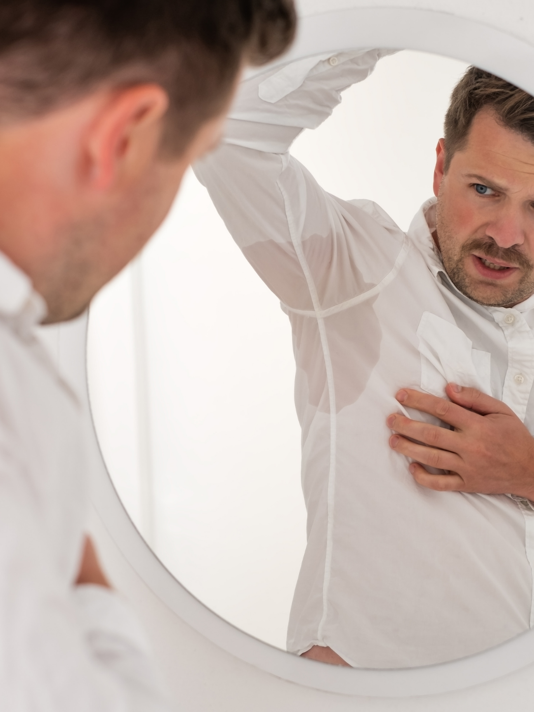 Person with visible sweat through shirt, a sign of hyperhidrosis