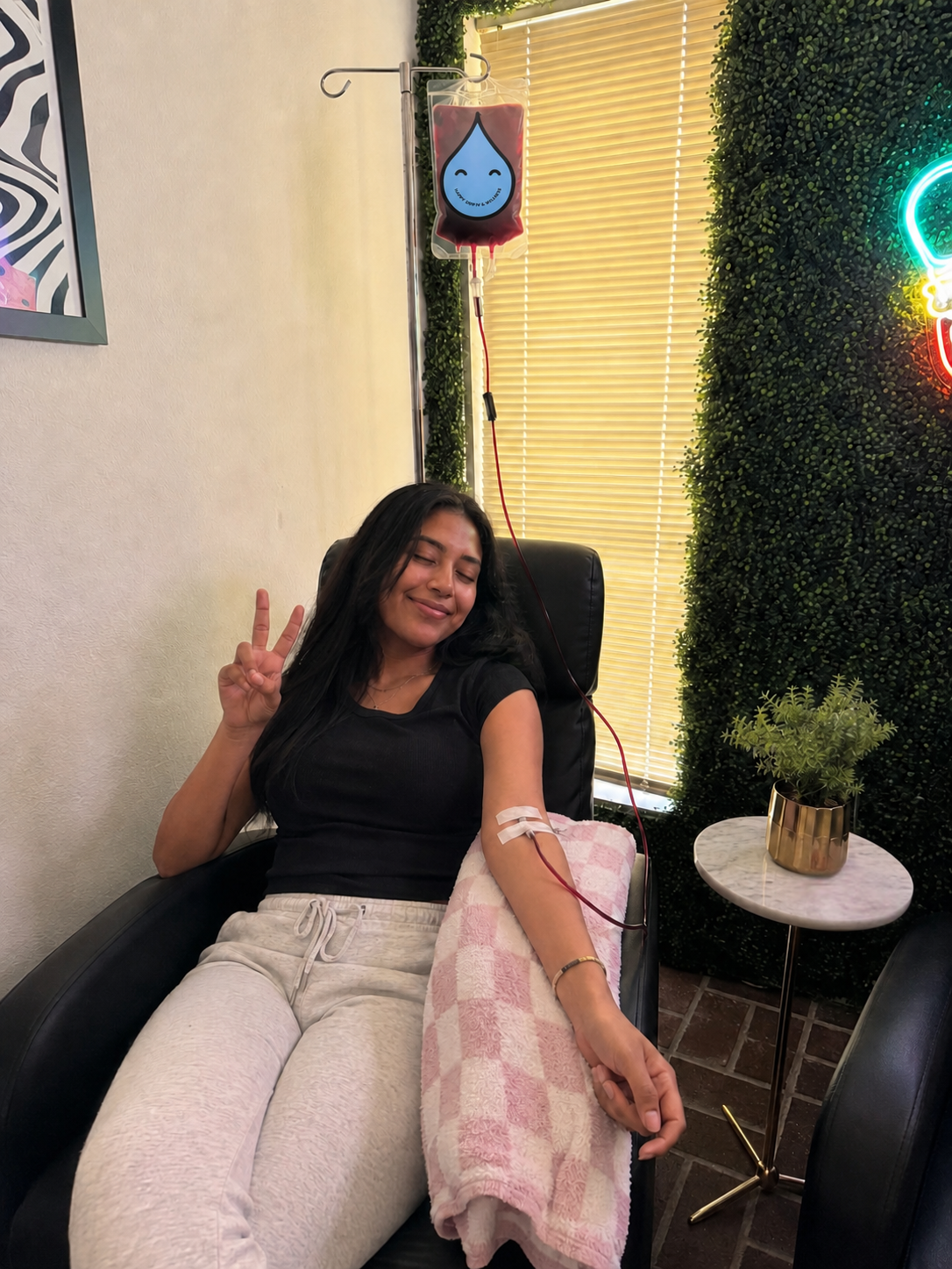Happy patient giving a peace sign during her IV iron infusion at Happy Drip IV & Wellness